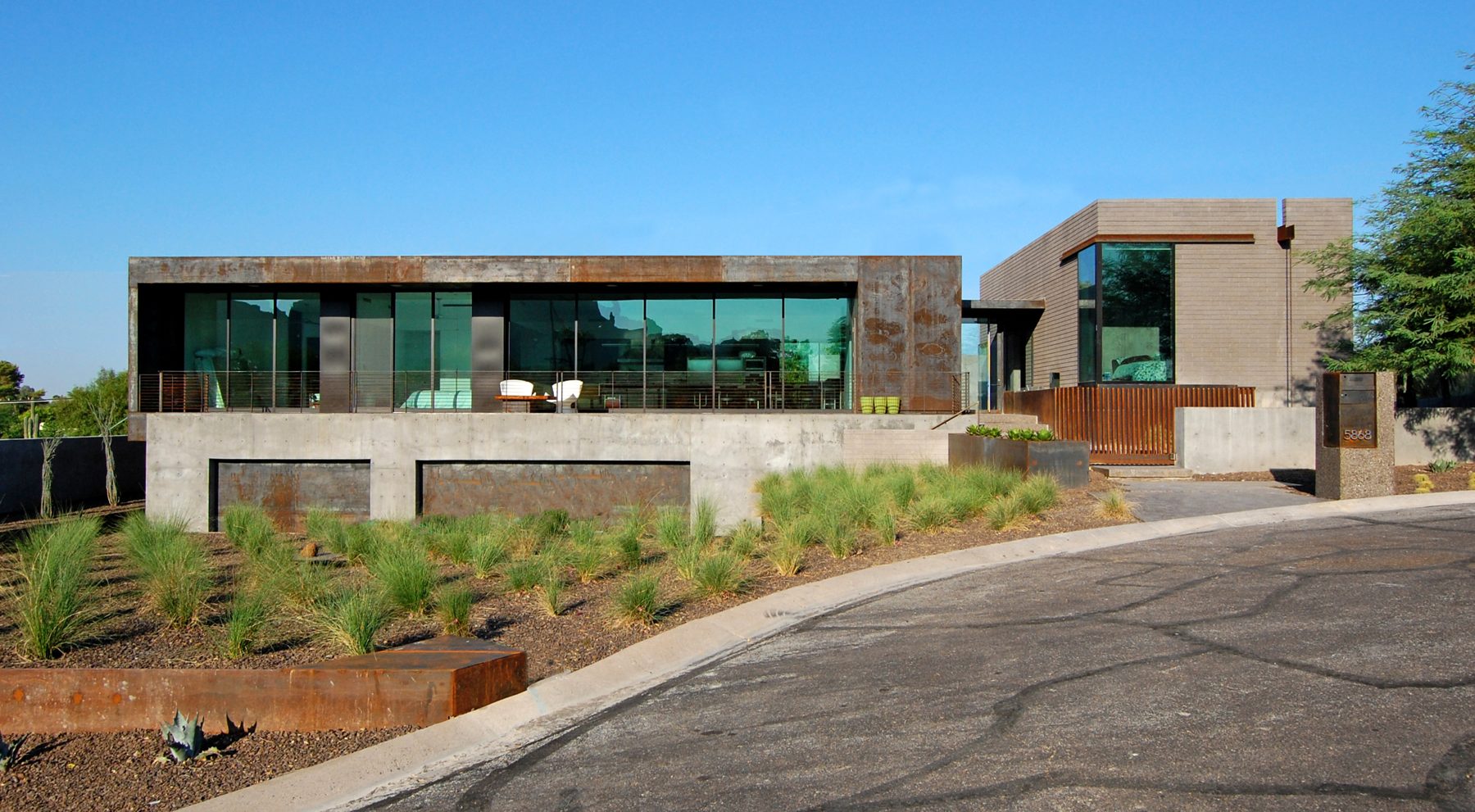 The finished Modern Bunker residence with weathered steel cladding and glass